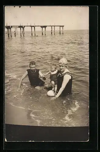 Foto-AK Mutter mit ihren zwei Kindern am Strand, Bademode