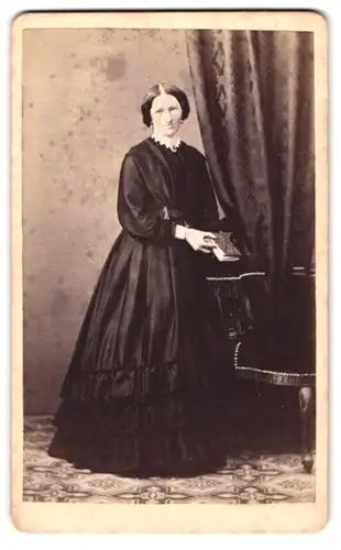 Fotografie L. Strobel, Kempten, junge Dame im tief schwarzen Kleid mit Fotoalbum in der Hand