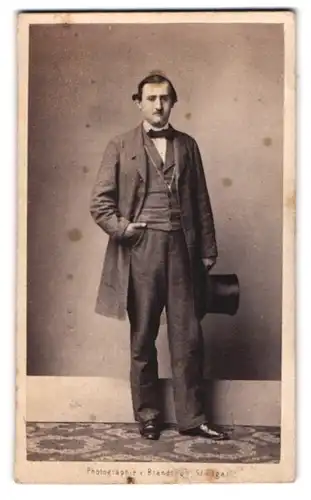 Fotografie Brandseph, Stuttgart, junger Mann im grauen Anzug mit Zylinder in der Hand
