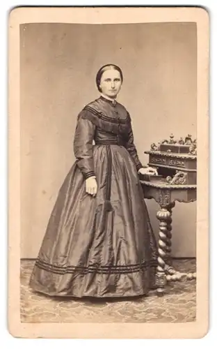 Fotografie F. Halm, Constanz, Dame im seidenen Kleid posiert stehend am Sekretär