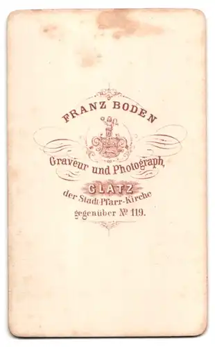 Fotografie Franz Boden, Glatz, junge Frau im Reifrockkleid stehend am Sekretär