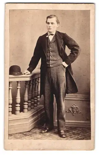 Fotografie A. Reinhard, Pirmasens, junger Mann im karierten Anzug mit Mantel und Melone