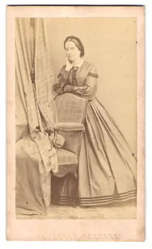 Fotografie unbekannter Fotograf und Ort, Dame im Kleid posiert hinter einem Stuhl