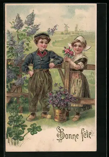 Präge-AK Zwei Kinder in Trachten stehen an einem Zaun mit Blumen