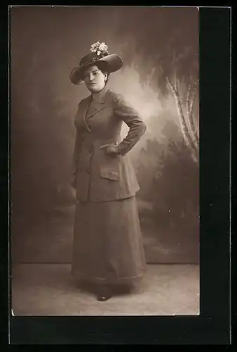 Foto-AK Frau in Kostüm mit Hut vor Studiokulisse