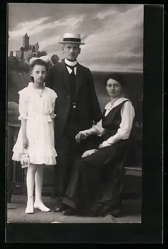 Foto-AK Ernst blickende Familie vor Studiokulisse