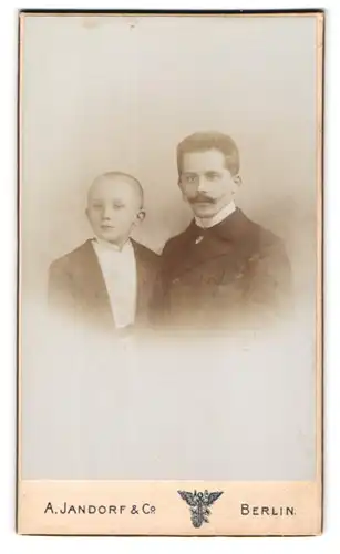 Fotografie A. Jandorf & Co., Berlin, Gr. Frankfurterstr. 113, Portrait stolzer Vater mit Schnurrbart & frecher Bube
