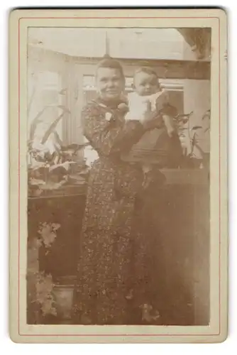 Fotografie unbekannter Fotograf und Ort, Portrait stolze Mutter hält ihr Baby im Arm