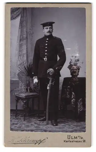 Fotografie H. Schrempf, Ulm a. D., Soldat in dunkler Uniform mit Säbel und Portepee