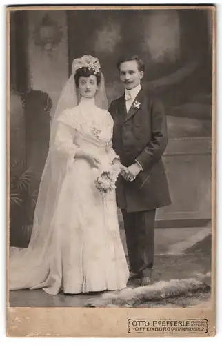 Fotografie Otto Pfefferle, Offenburg, junges Brautpaar im weissen Kleid und im Anzug mit Brautstrauss