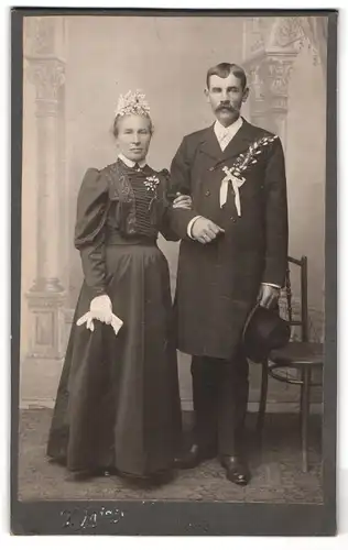 Fotografie unbekannter Fotograf und Ort, Ehepaar im schwarzen Brautkleid und Anzug mit Ansteckblume