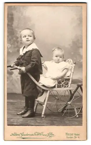 Fotografie Albert Gudenrath Wwe. und Sohn, Heide i. Holst., junger Knabe mit seiner Schwester im Kinderwagen