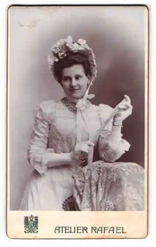 Fotografie Atelier Rafael, Brünn, Frau Itha Schinko im weissen Kleid mit Rüschen und Haube, Fächer, 1900