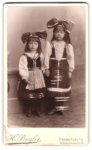 Fotografie H. Bogler, Frankfurt / Main, zwei kleine Mädchen in Trachtenkleidern mit Schleife auf dem Kopf