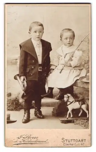 Fotografie J. Steoss, Stuttgart, zwei Kinder mit Belchtrompete und Spielzeug Pferd samt Peitsche