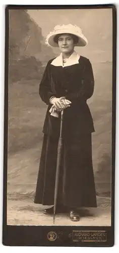 Fotografie Richard Landes, Wiesloch, Dame im dunklen Samtkleid mit Sonneschrim und Hut