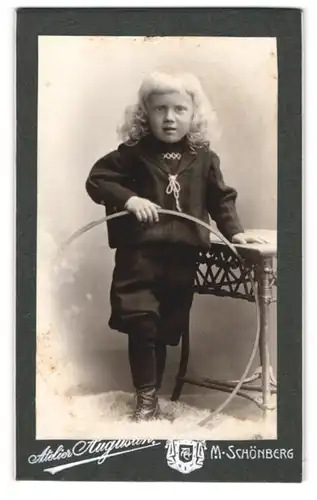 Fotografie August Mayr, Mährisch Schönberg, blondes Kleinkind im schwarzen Anzug mit lockigen Haaren