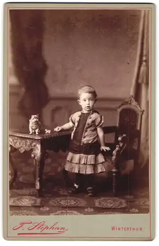 Fotografie F. Stephan, Winterthur, Kleinkind im Kleid mit Kummerbund