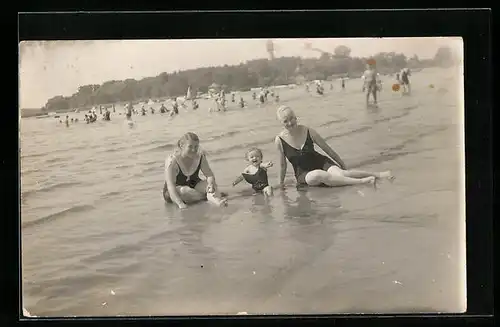 Foto-AK Zwei Frauen und ein Kind spielen im Sand