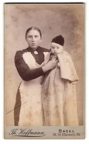 Fotografie Th. Hoffmann, Basel, Amme in Dienstuniform mit jungen Schützling im Arm