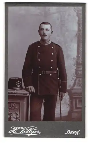 Fotografie H. Völlger, Bern, schweizer Soldat in Uniform Rgt. 33 mit Tschako