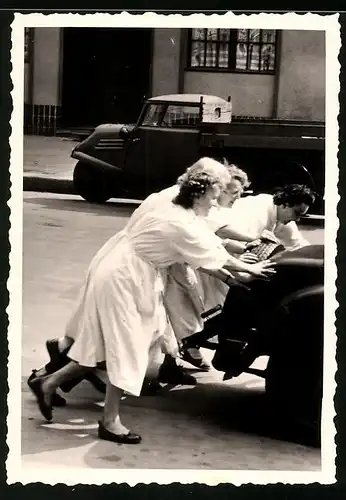 Fotografie Damen schieben ein Auto aus dem Weg