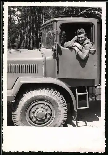 Fotografie Kraftfahrer in Uniform sitzt im Lastwagen, LKW-Führerhaus