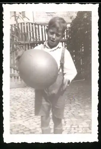 Fotografie Knabe in Lederhose spielt mit einem Ballon