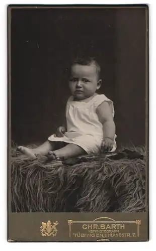 Fotografie Chr. Barth, Tübingen, Uhlandstrasse 7, Baby mit weinerlichem Blick auf einem Fell
