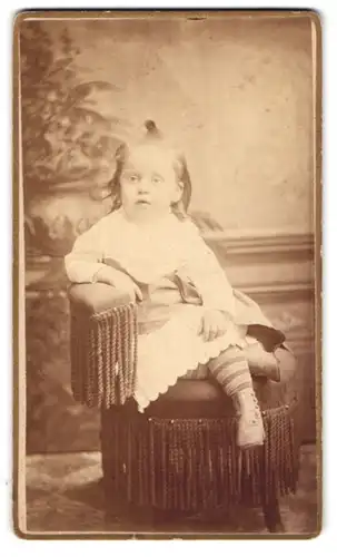 Fotografie De Forest, Detroit, Cor. Woodward Ave., Kleines Mädchen im weissen Kleid auf einem Sessel