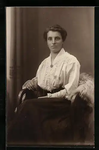 AK Frau in weisser Bluse auf Stuhl sitzend