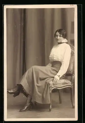 Foto-AK Frau in weisser Bluse auf Stuhl sitzend