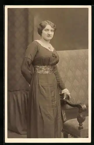 Foto-AK Frau im langen Kleid neben Sofa