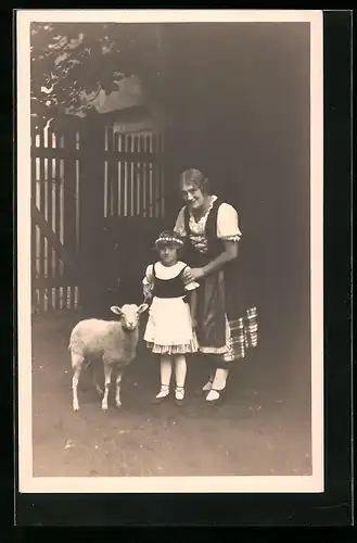 Foto-AK Johanna Schubert im Dirndl, mit einem kleinen Mädchen und einem Lamm