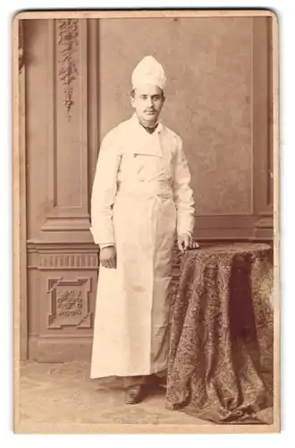 Fotografie Hermann Selle, Potsdam, junger Koch in Dienstbekleidung posiert im Atelier
