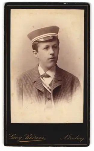 Fotografie Georg Schönau, Nürnberg, junger Student im Anzug mit Biedermeiermütze und Couleur