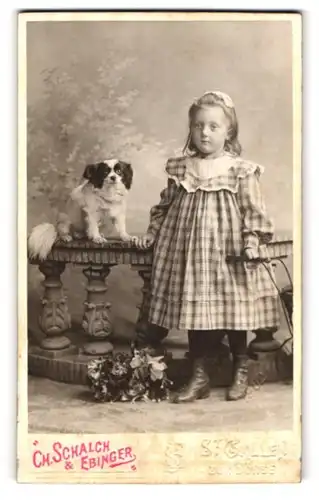 Fotografie Ch. Schalch & Ebinger, St. Gallen, kleines Mädchen im karierten Kleid mit ihrem Hund auf dem Tisch