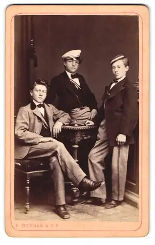 Fotografie F. Stephan & Cie., Winterthur, drei junge schweizer Studenten in Anzügen mit Biertönnchen und Couleur