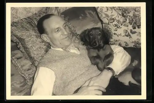 Foto-AK Mann mit Dackel im Arm auf einem Sofa