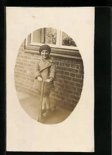 Foto-AK Mädchen im Mantel steht auf einem Roller