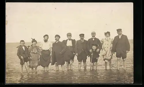 AK Gruppenbild Herren, Damen und Kinder ohne Bademode im Meer mit hochgekrempelten Hosenbeinen