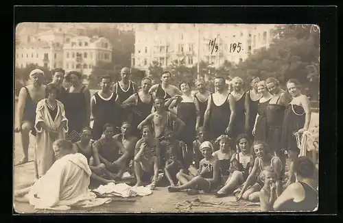 AK Gruppenfoto von Urlaubern in Bademode am Strand, die Hotels im Hintergrund