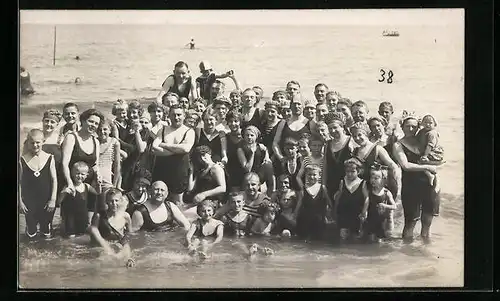 AK Eine grosse Gruppe Urlauber in Bademode im Wasser am Strand