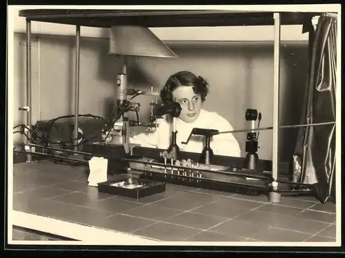 Fotografie Laborantin beim Versuchsaufbau eines physikalischen Versuchs