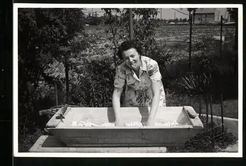 Fotografie Hausfrau beim Wäsche waschen in einem grossen Holzzuber