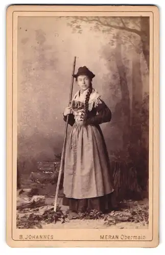 Fotografie B. Johannes, Meran, Portrait junge Frau im Trachtenkleid mit geflochtenem Zopf im Atelier