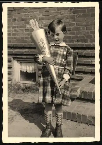 Fotografie Einschulung, kleines Schulmädchen mit Zuckertüte am ersten Schultag