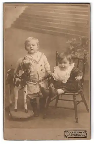 Fotografie Max Rother, Nossen, zwei niedliche kleine Kinder mit ihrem Schaukelpferd im Atelier