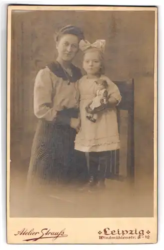 Fotografie Atelier Strauss, Leipzig, Mutter mit ihrer Tochter im weissen Kleid und Puppe im Arm, Haarschleife