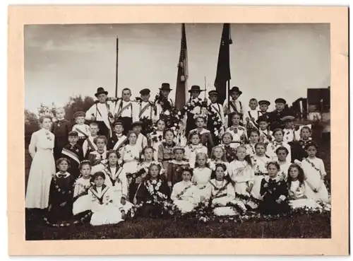 Fotografie junge Knaben und Mädchen zum Schützenfest mit Armbrust und festlich geschmückt, Flaggen